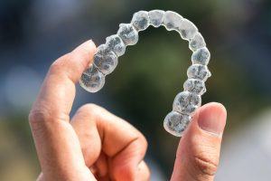 person holding Invisalign tray