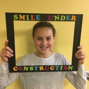 smiling girl holding sign