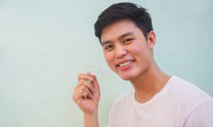 teen boy holding invisalign tray