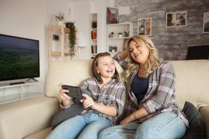 smiling mom and little girl with braces at home 