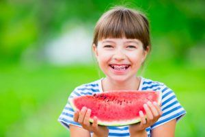 young girl with braces in Powell eating watermelon