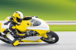 man riding yellow motorcycle very fast 