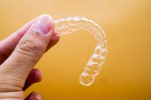 hand holding an Invisalign tray 