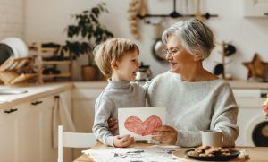 young child sitting at table with grandmother 