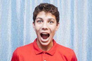 teen boy with braces looking excited 