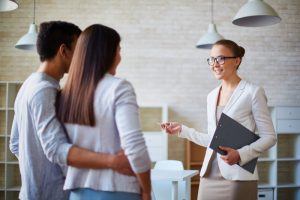 female realtor talking to couple in house 