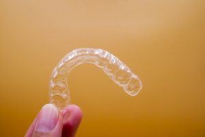 closeup of hand holding Invisalign tray 