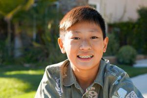 young boy outside with braces 