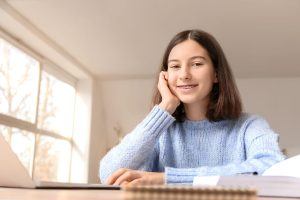 young girl with braces studying at home